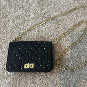 Small black purse with gold accents and long chain